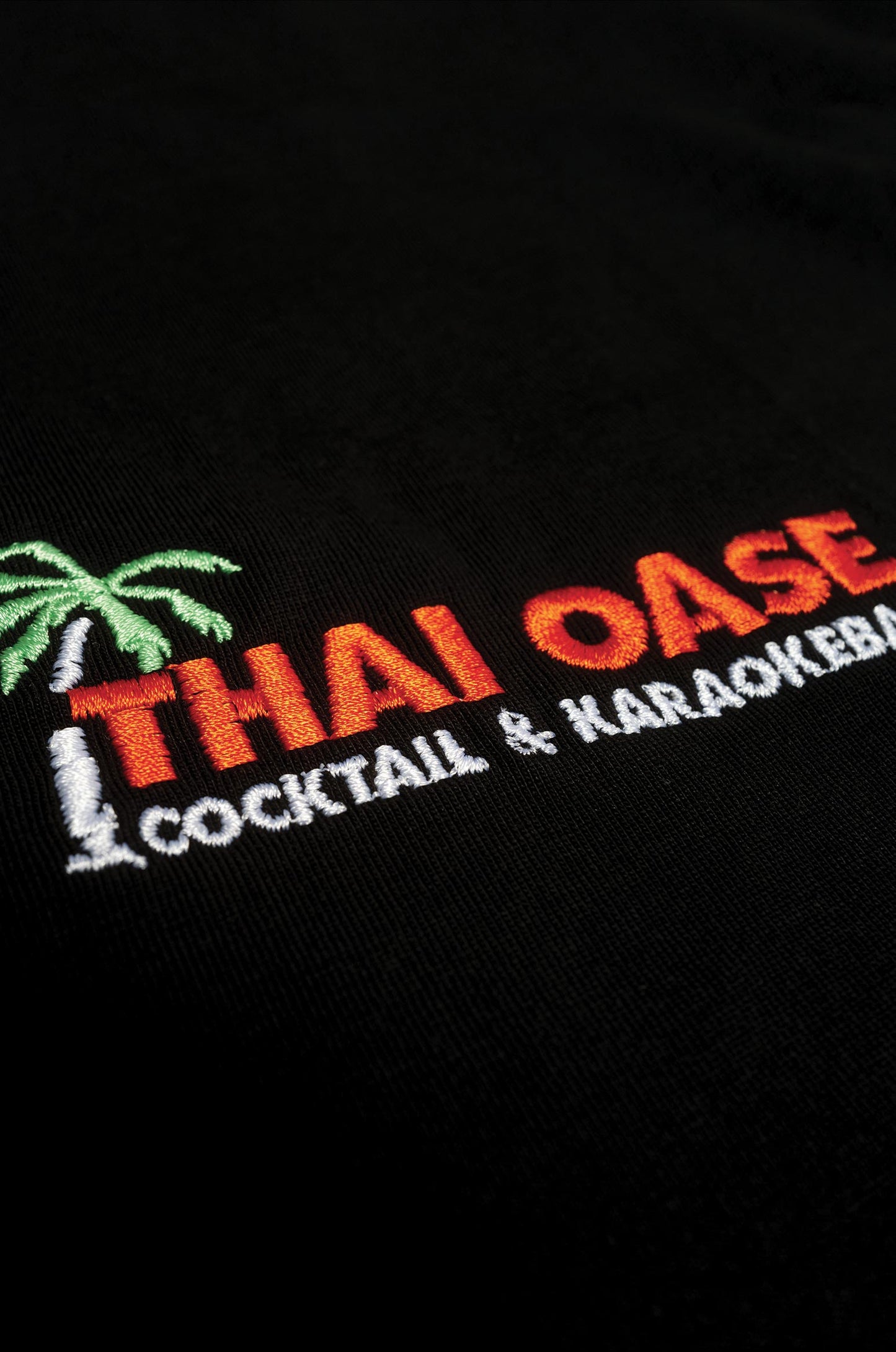 Detailbild von dem gesticktem Logo von der Thai Oase auf dem Premium Shirt