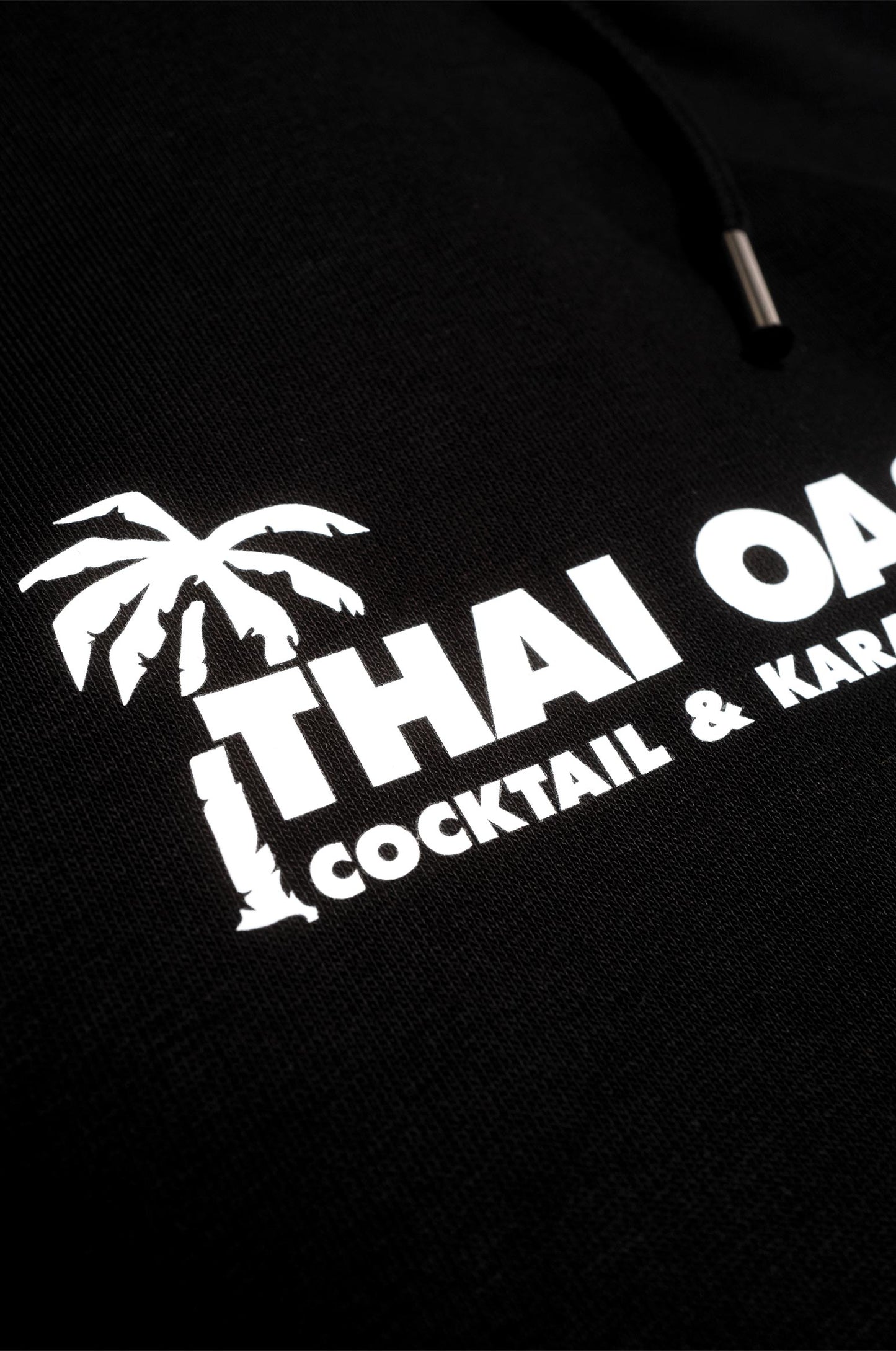 Detailaufnahme Thai Oase Logo auf dem Iconic Hoodie in Schwarz.